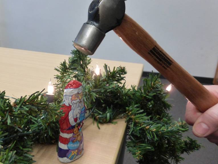 Hammer schlägt auf Schokoladen-Weihnachtsmann