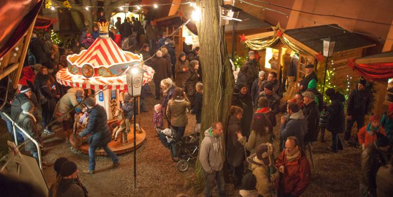 Weihnachtsmarkt mit  Holzbuden und Kinderkarussell