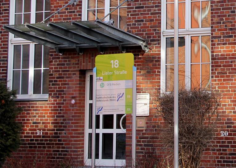 Eingangstür eines roten Backsteinhauses.