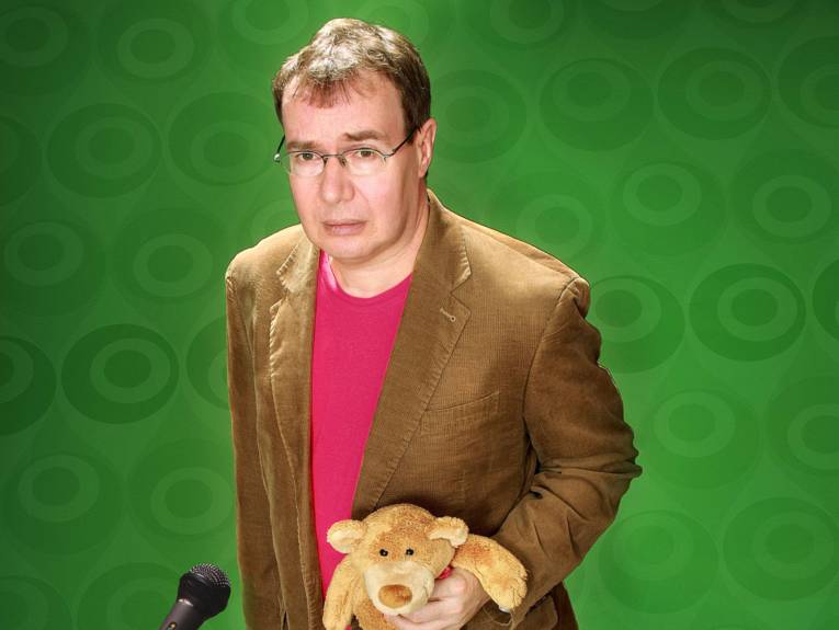 Bedröppelt dreinschauender Mann mit einem Teddy in der Hand.