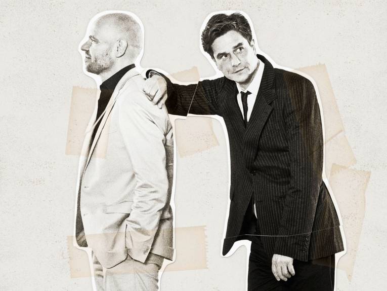 Ein Mann lehnt sich auf die Schulter eines anderen Mannes.