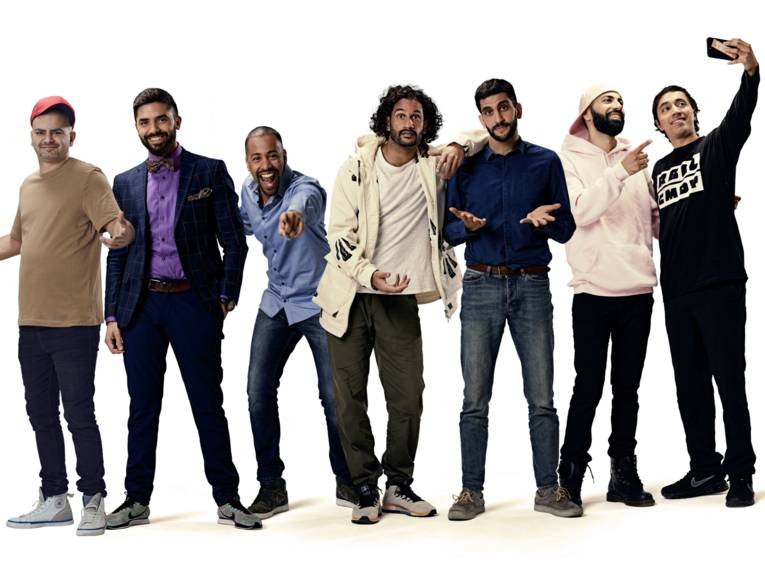 Sieben Männer in einer Reihe in unterschiedlichen Posen