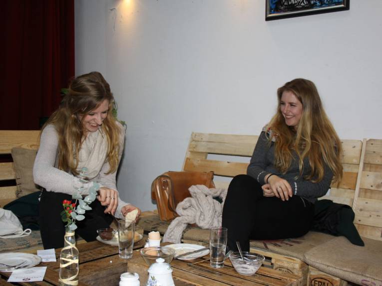 Zwei Frauen sitzen in einem Café und essen.