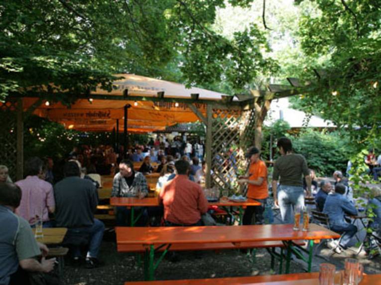 Menschen auf Bänken an Tischen im Freien