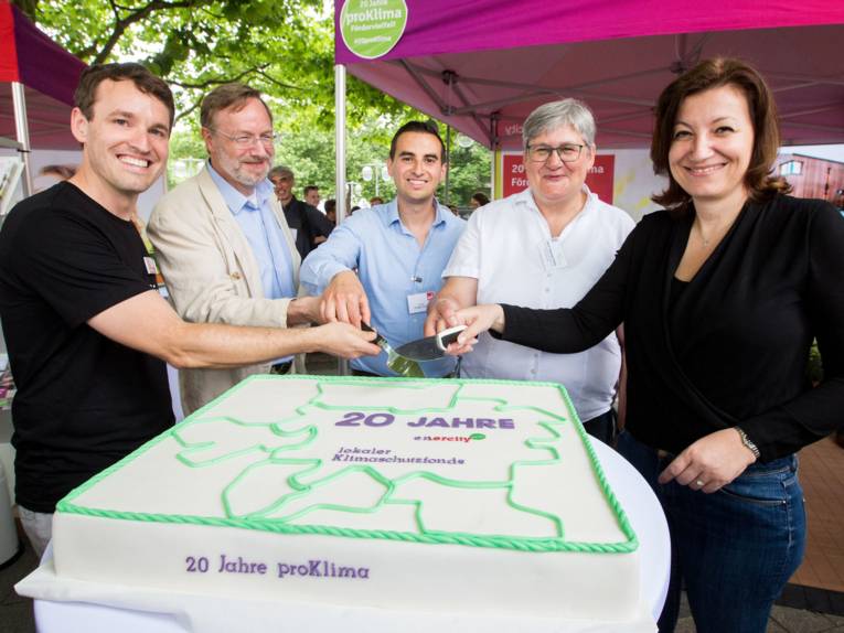 Zwei Frauen und drei Männer schneiden symbolisch eine Torte mit der Aufschrift "20 Jahre proklima" an.