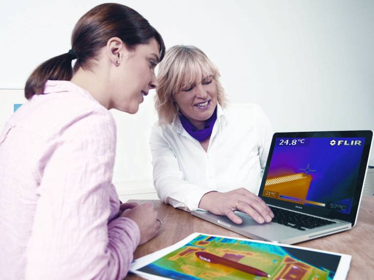 Zwei Frauen blicken auf ein Notebook