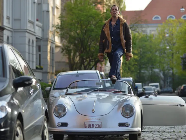 Mann steht in einem Cabriolet.