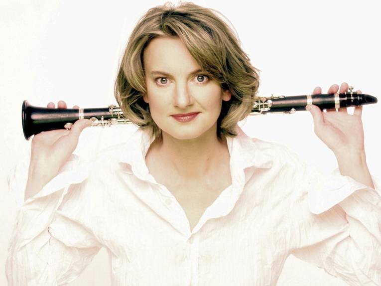 Frau hält eine Klarinette hinter dem Kopf