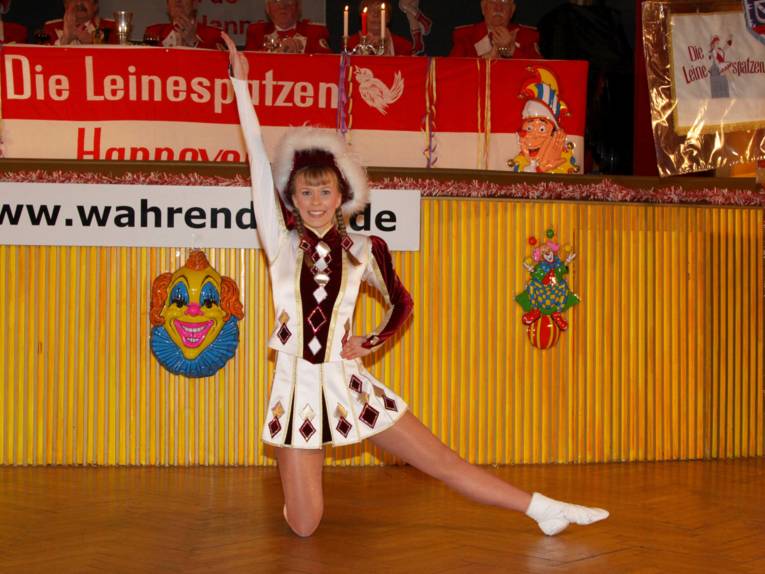Junges Mädchen in Tanzmariechen-Uniform in Tanzpose. 
