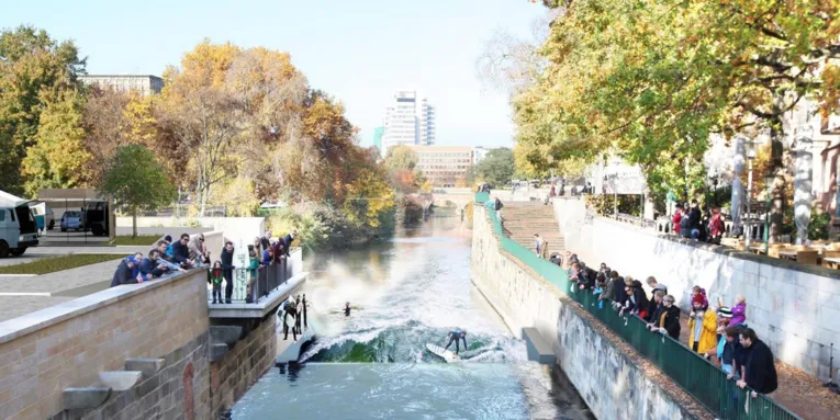 Computergenerierte Grafik von Surfern in einem Fluss, dessen Ufer durch Mauerwerk befestigt sind.