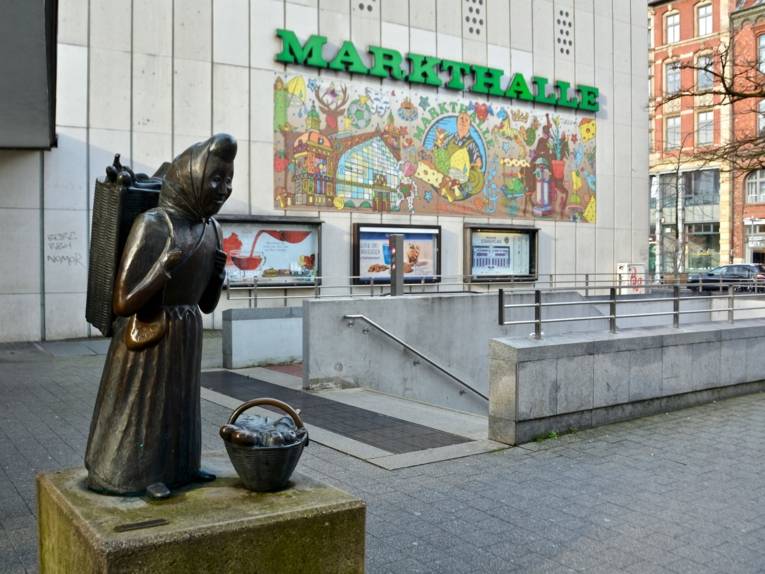 Bronzefigur, die eine Marktfrau mit Korb darstellt