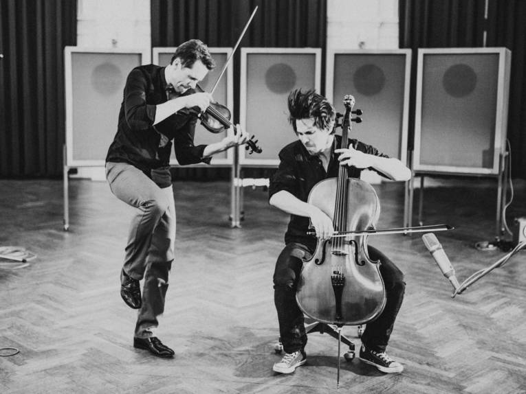 Zwei Männer spielen Violine und Cello.