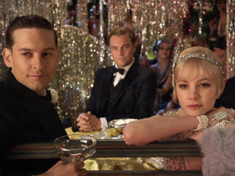 Zwei Männer und eine Frau sitzen an einer Bar.