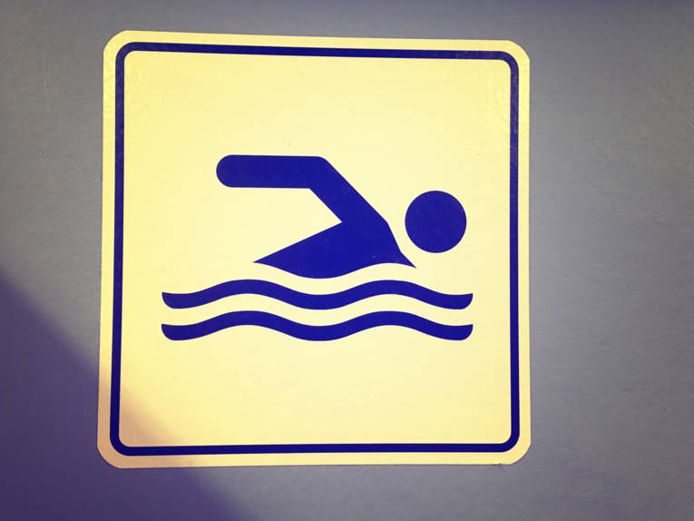 Ein Schild zeigt das Piktogramm eines Schwimmers.