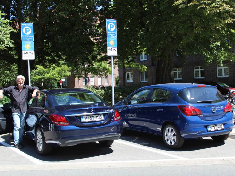 Mann und zwei parkende Autos