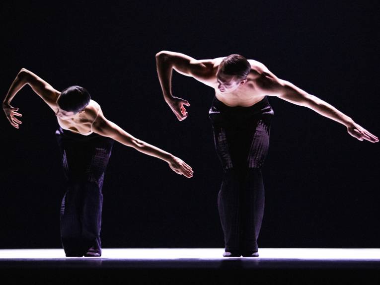 Zwei Personen in tänzerisch-akrobatischer Pose auf einer Bühne