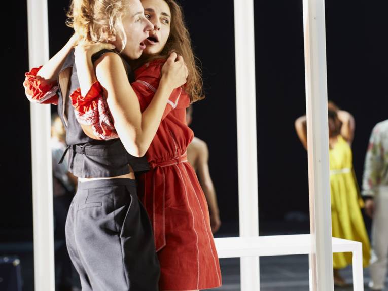 Zwei Frauen mit offenen Mündern umarmen sich