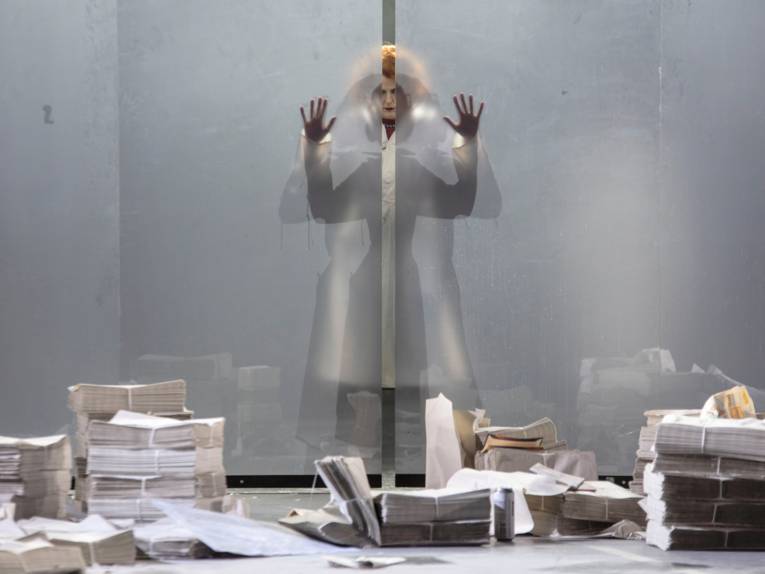 Bühnenszene: Frau im Badeanzug cremt sich ein, daneben ein Mann in kurzer Hose mit geballten Fäusten