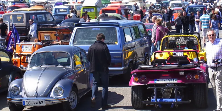 Viele Fahrzeuge auf einem Parkplatz, den Autokennzeichen nach aus vielen verschiedenen Städten.