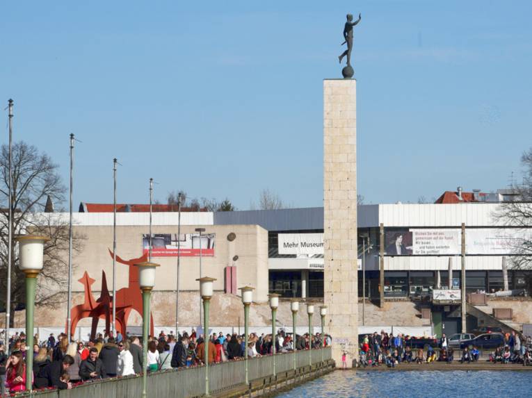Menschen um einen See.