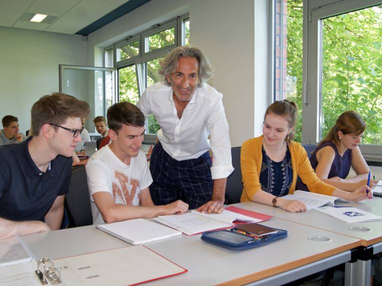Foto: Prof. Dr. Christof Zwecker mit Studierenden der Fachhochschule für die Wirtschaft im Unterrichtsraum.