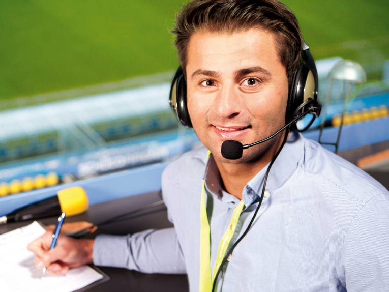 Junger Mann mit Mikrofon, Block und Stift