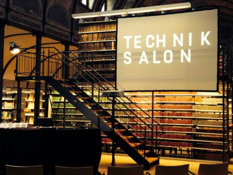 Ein Lesesaal, auf einer Leinwand steht der Schriftzug Technik Salon