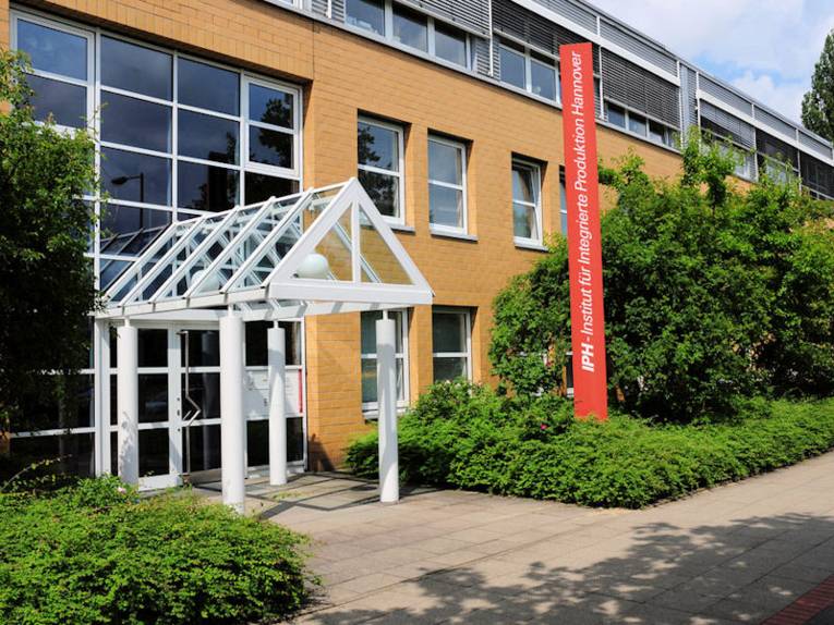 Eingang eines Gebäudes mit Pylon mit der Aufschrift "IPH – Institut für Integrierte Produktion Hannover"