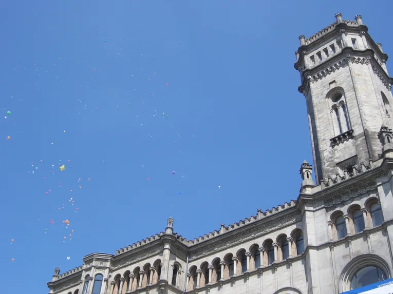 Bunte Ballons vor einem älteren Gebäude.