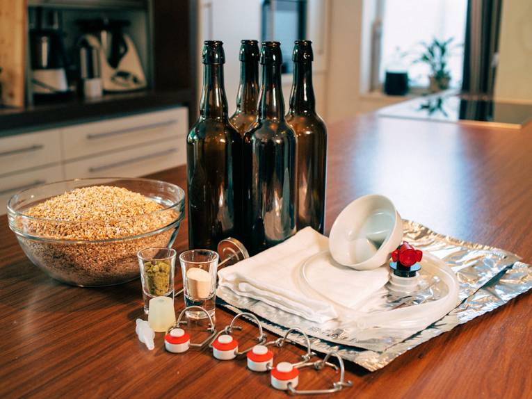 Flaschen, Küchengeräte und Lebensmittel auf einem Tisch.