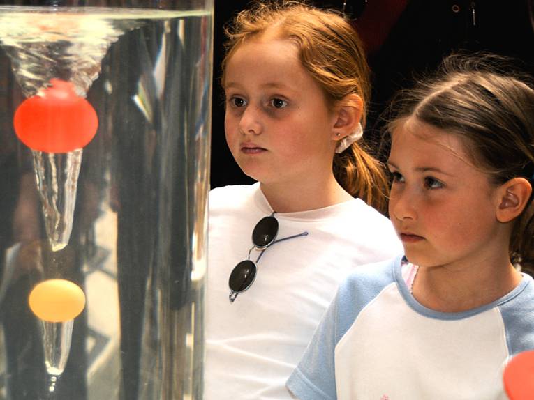 Zwei Mädchen beobachten ein physikalisches Experiment