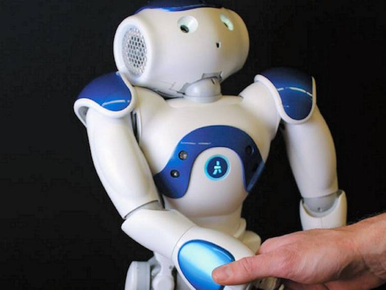 Roboter gibt menschlicher Hand die Hand.