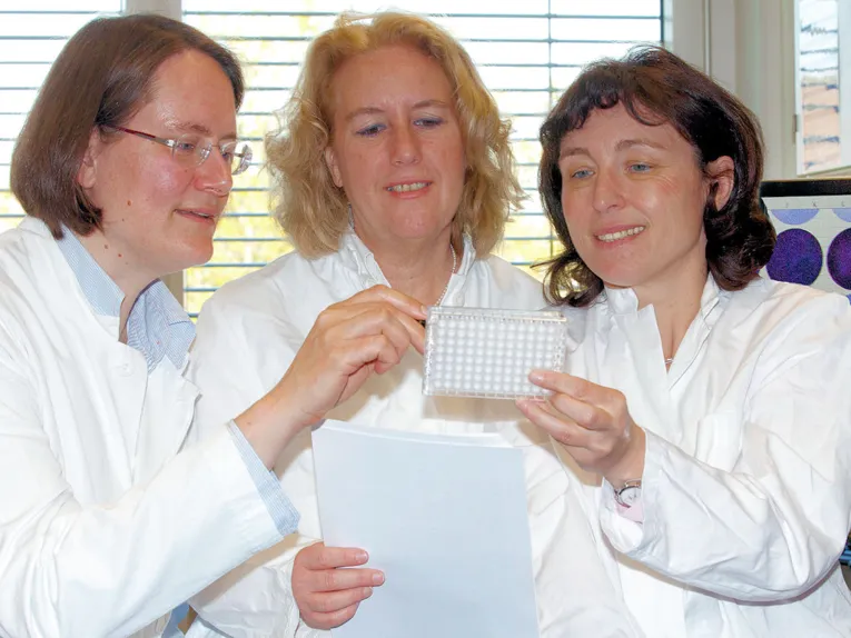 Drei Frauen in weißen Kitteln.