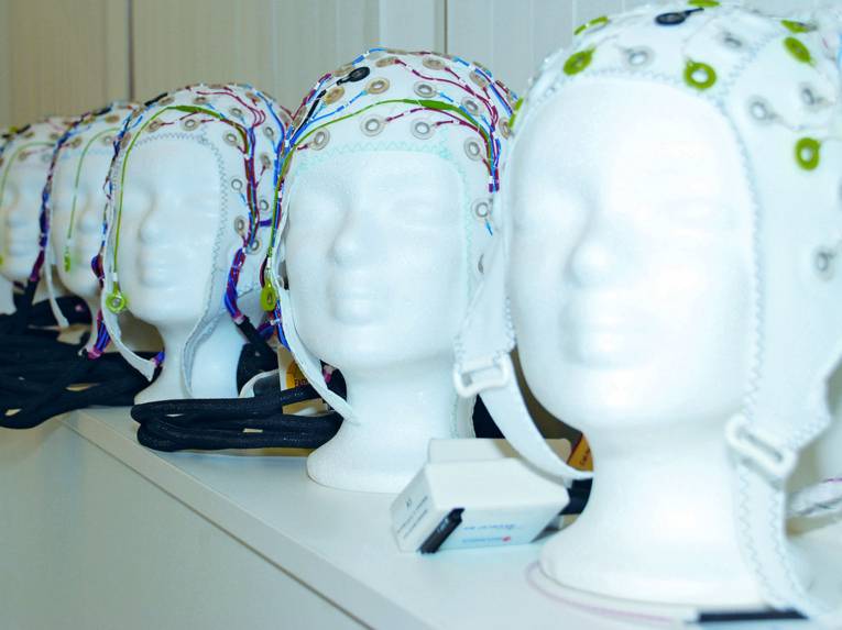 Mehrere Modellköpfe mit Kappen.