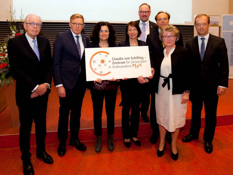 Drei Frauen und fünf Männer mit einem Schild mit der Aufschrift "Claudia von Schilling-Zentrum für Universitäre Krebsmedizin"