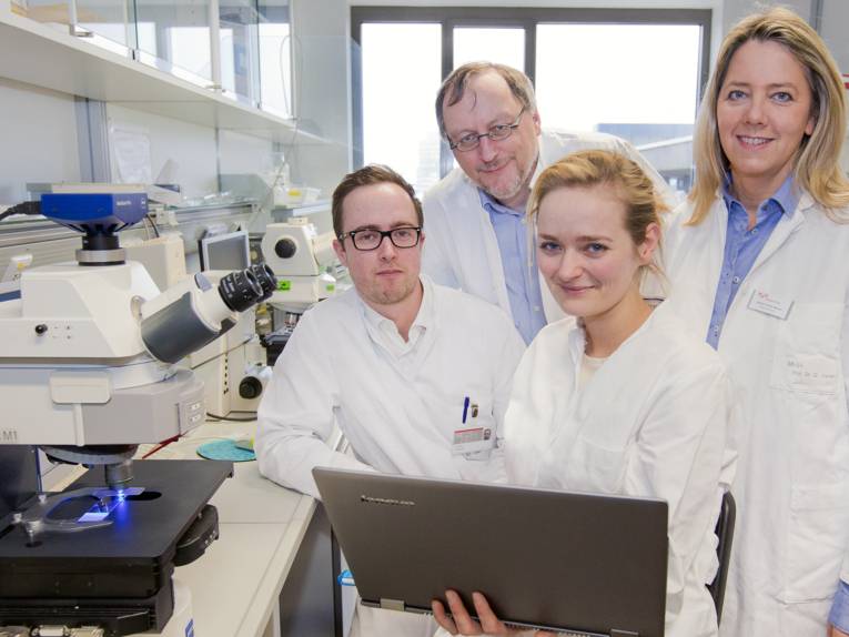 Vier Personen in weißen Kitteln in einem Labor