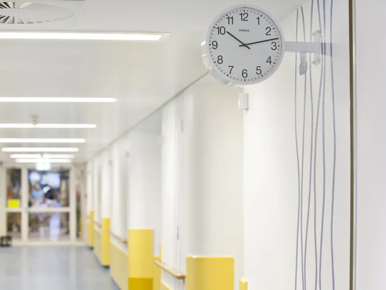 Eine Uhr hängt an der Wand in einem großen Flur.