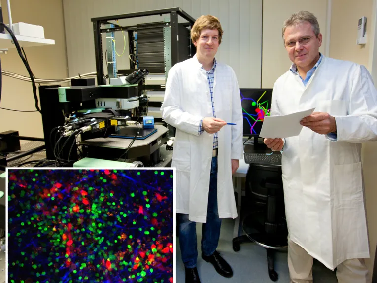 Zwei Männer in weißen Kitteln mit wissenschaftlichen Geräten und integriertem farbigem Bild