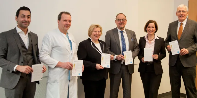 Menschen einen Zettel in die Kamera haltend