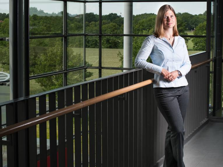 Eine Frau lehnt an einem geländer.