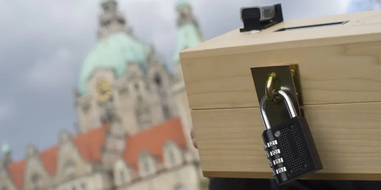 Holzbox mit Zahlenschloss und kleinen elektronischem Gerät
