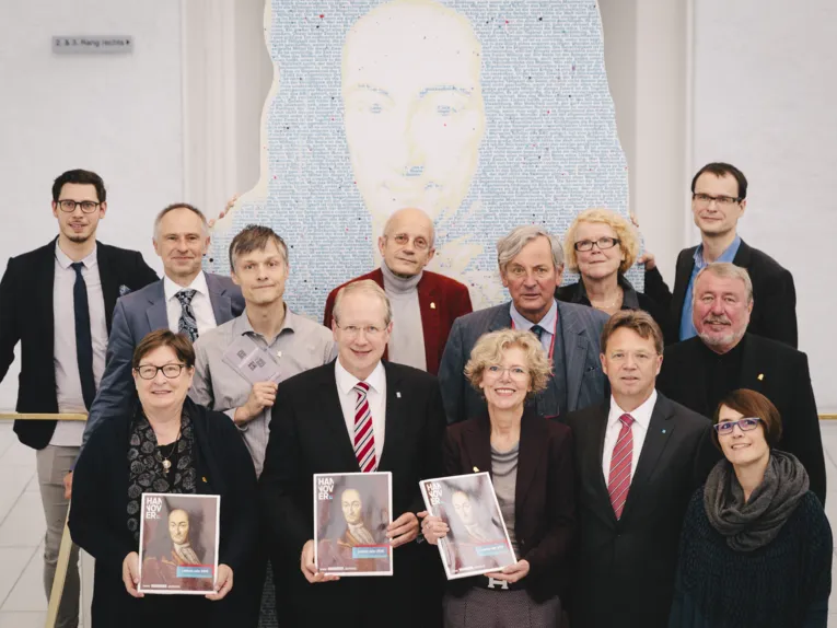 13 Personen auf einer großen Treppe