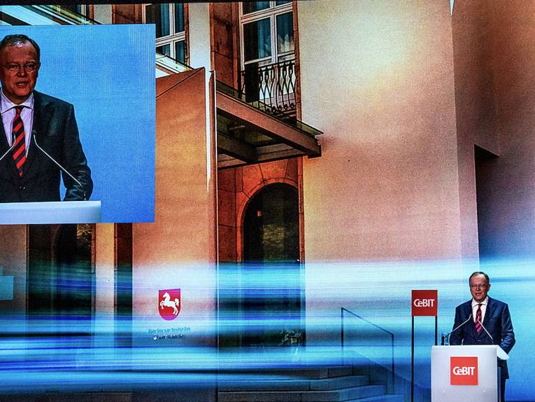 Mann an Rednerpult mit der Aufschrift "CeBIT"