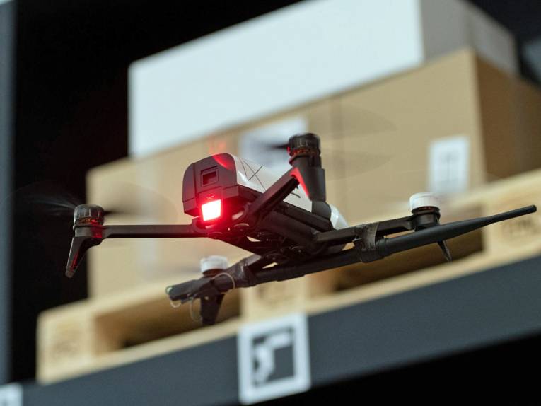 Drohne fliegt vor Paketregal