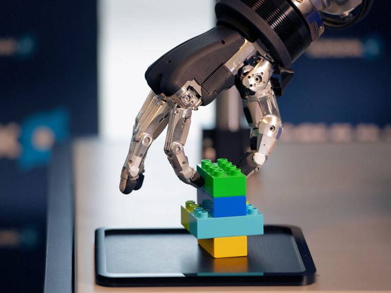 Roboterhand mit Legosteinen