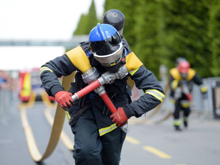 Mann in Feuerwehruniform mit Gasmaske