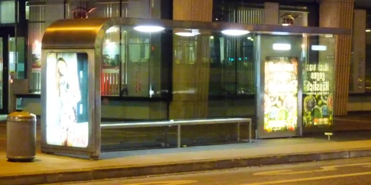 Beleuchtete Bushaltestelle in der Nacht.