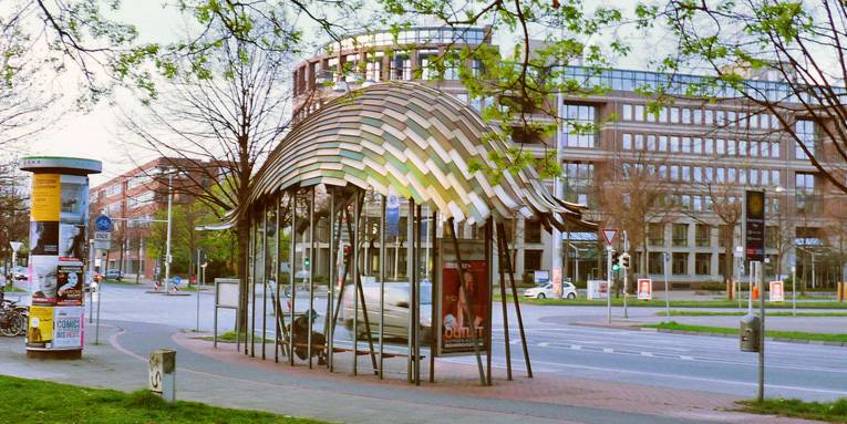 Bushaltestelle mit Dach aus Metallgeflecht.