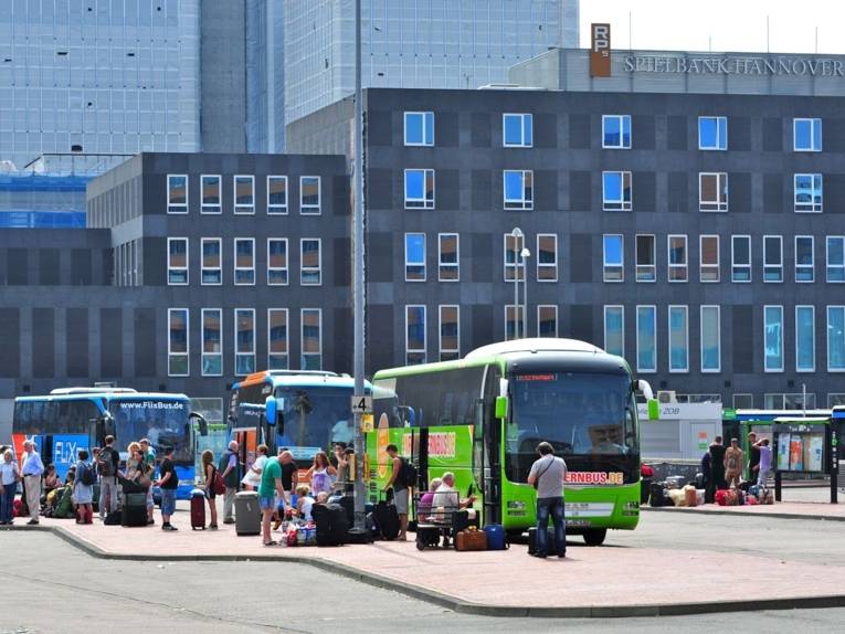 Ein grüner Bus am Bahnhof. 