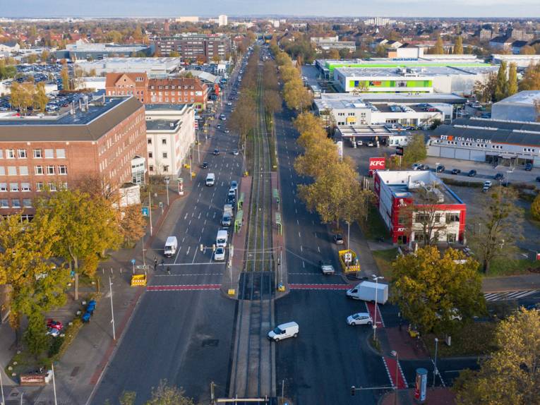Luftbild einer vierspurigen Straße mit Stadtbahnlinien in der Mitte.